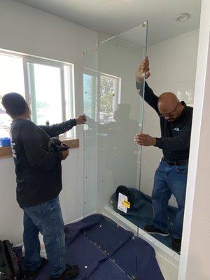 The guys putting in the shower glass