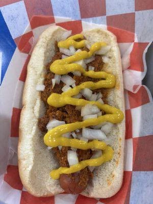 Hot dog with onions, mustard and chili.