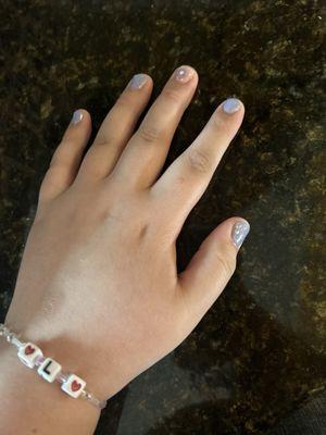 Purple nails, sparkly, with flower on middle finger