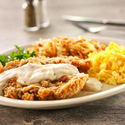 Chicken Fried Steak Breakfast - Hand-battered steak topped with cream gravy, served with two eggs, your style.