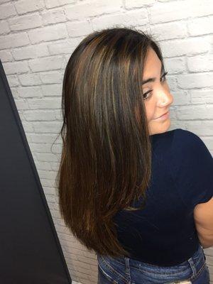 Long layered hair cut with natural highlights and baby lights.