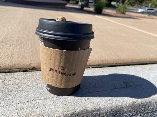 Vanilla latte with chocolate covered coffee bean on top.