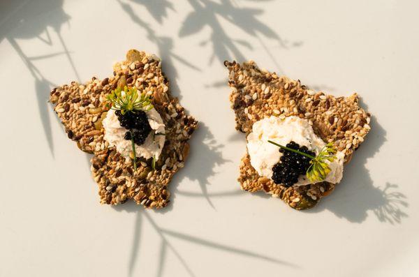 seeded cracker with salmon mousse, caviar, chive blossom