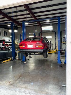 View of my car on the lift in their clean and organized shop.