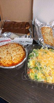 Lasagna, salad, cheese bread sticks and cinnamon bread