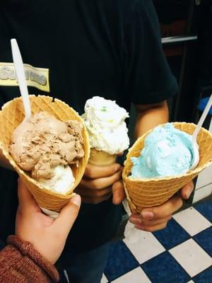 Cone 1: Chocolate, raisins & nuts, & cheesecake w/ crumbs (scoop 2),  Cone 2: Vanilla w/ nerds Cone 3: blue smurf ice cream.