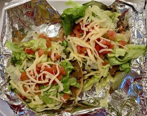 Tostadas with Steak, Refried Beans, Lettuce, Tomatoes, and Shredded Cheese