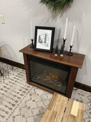 Cozy couch next to an electric fire place.