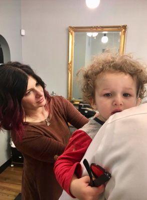 Bridget the " curl master" giving this curly kiddo his first curly cut!