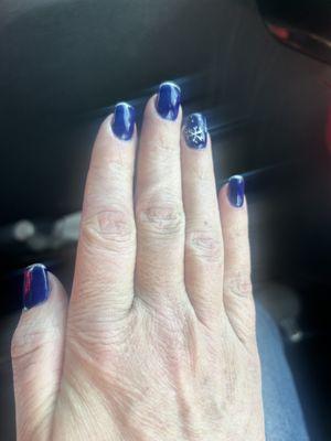 Dark blue nails with silver tips; snowflake design on ring fingers.