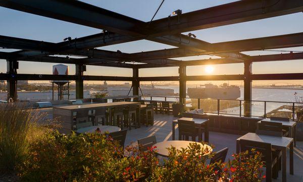 The rooftop terrace lounge, featuring areas for seating, grilling, and dining