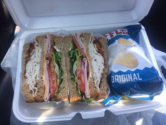 Club sandwich with chips and pickle on the side