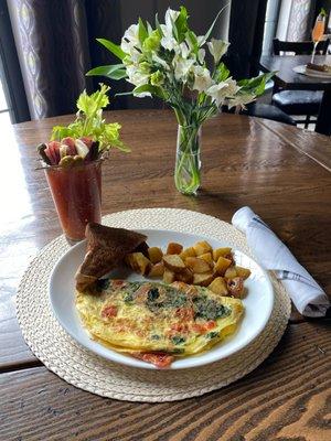 Greek Omelet made with all fresh ingredients and hand cut potatoes with toast paired with our House Bloody