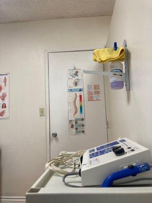 Room with electric therapy machine and spray bottle. Masks are mandatory here and the rooms are clean.