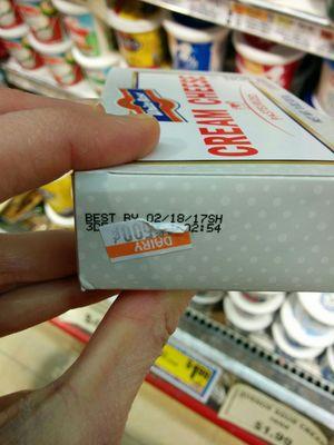 Price labels covering the expiration date on every package of already expired cream cheese. Photo taken on February 26th.