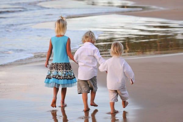 Siblings going for a little walk on the beach together.