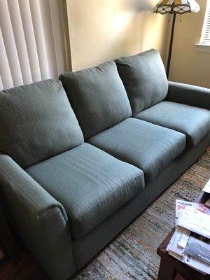 Sofa is green. Not grey