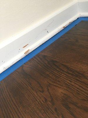 Baseboards damaged as they were not properly protected/taped. This shows our tape for repaint.