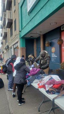 Repartiendo ropa y comida a la comunidad los domingos despues del servicio