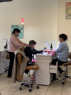 T Spa nail salon staff giving a manicure and neck massage