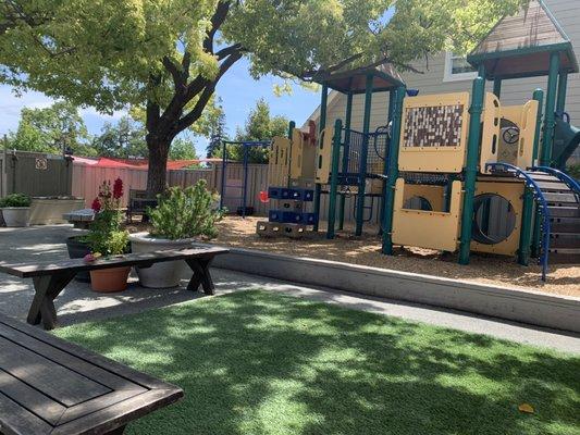 Our outdoor space includes two sandboxes, a bike track, play structure, swings, and grassy area.