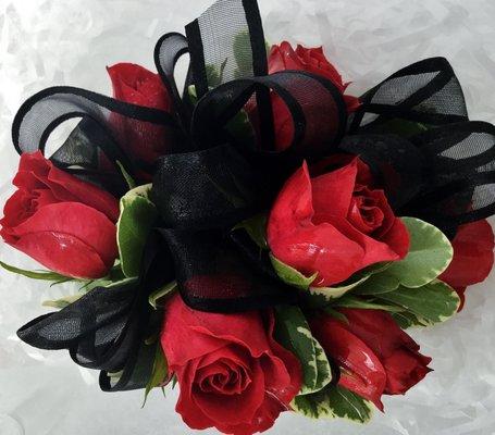 A Beautiful Corsage made of Red Sweetheart Roses with a Black Ribbon is a stunning addition to a perfect dress.