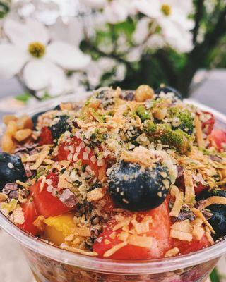 This bowl features fresh blueberries, strawberries, hemp hears, cacao nibs, toast coconut and matcha powder.