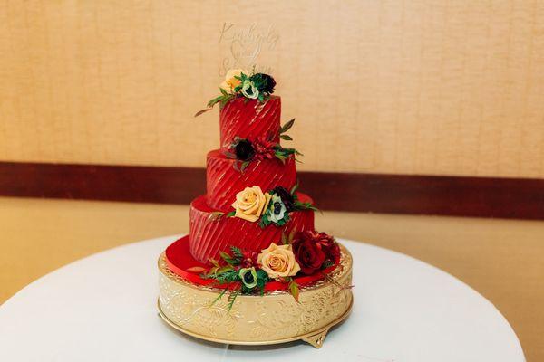 Three tiered red wedding cake with flowers from Wildflowers at the Lake