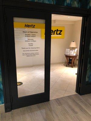 Hertz Car Rental Located INSIDE the Renaissance Hotel, just past the front desk.