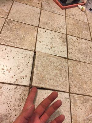 Tile lifting up and the grout is cracked.