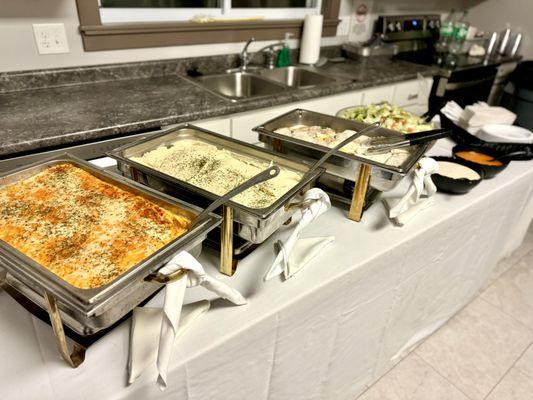 Spread of herbed boneless chicken breasts, macaroni and cheese, and whipped potatoes along with garden salad.