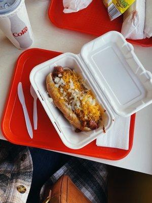 Chili cheese dog with mustard and onions.