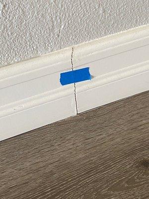 Cracked baseboard in my entry way that was painted over but keeps coming apart