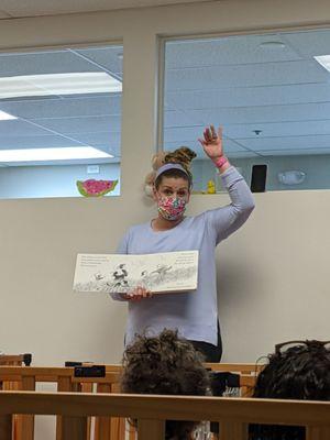 Ms Bethany reading a book at Teddy Bear Picnic