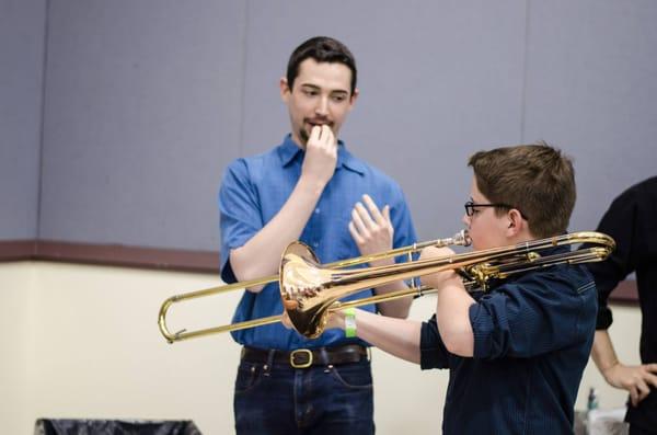 PSO musicians showing young concert goers how to play an instrument before a PSO Discovery! concert.