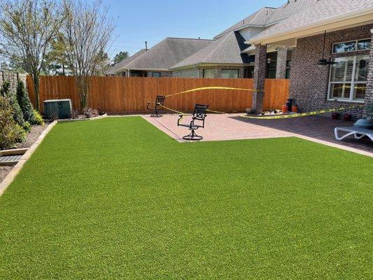 backyard installation of paver patio and low maintenance, pet-friendly artificial grass that stay green year round.  Houston, TX area.