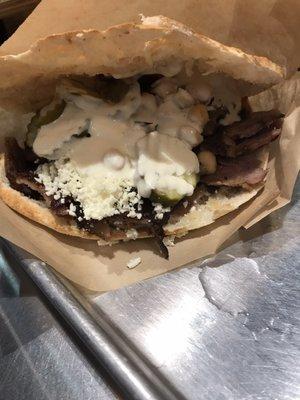 Pocket with beef, pickles, garbanza salad, feta and garlic sauce