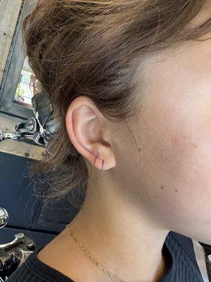 Mapping her ear with a marker to make sure the second piercing is in alignment with her ear fold and first piercing. Really impressive.