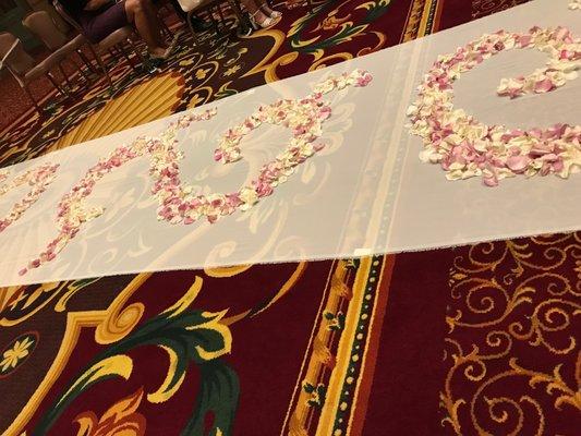 This is what I saw walking down the aisle. Pink flowers and sheer fabric runner taped down with visible masking tape.