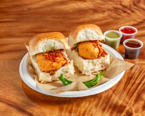 The dish consists of a deep fried potato dumpling placed inside a bread bun sliced almost in half through the middle.