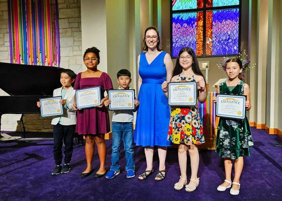 Pfluger Rock students with teacher at piano recital.