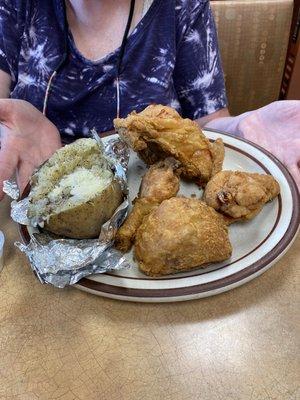 Fried chicken a little undercooked. Baked potato