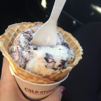 Marshmallow ice cream with candy cane and brownie in a waffle cone.