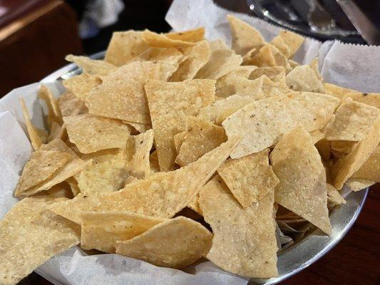 Crushed up chips. They came long after the queso was plopped on the table.