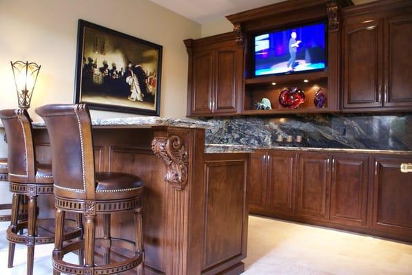 Enhance your home with a state of the art bar featuring a large flat screen TV and large solid wood corbels and moldings.