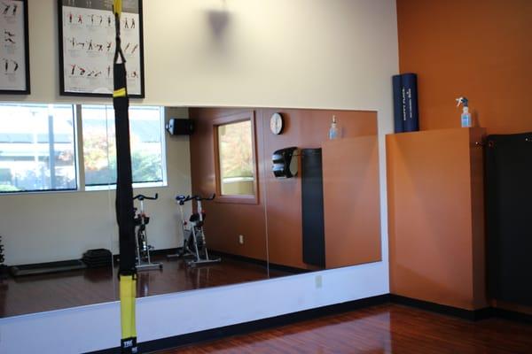 Small fitness room with spin bikes, TRX, and Wellbeats classes (projection classes available 24/7).