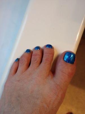 Gel glitter polish with a solid blue base layer.