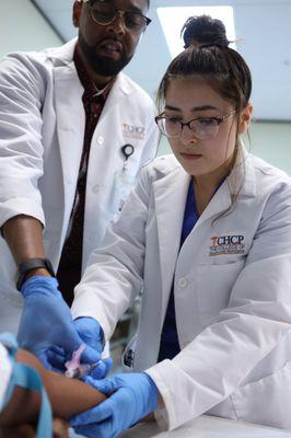 Medical Assistant student learning how to draw blood and comfort the patient through the procedure.