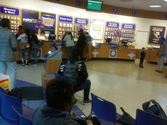 Two employees at Metro PCS trying to help 10 customers.....no other employees on the