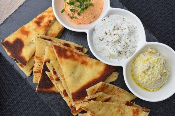 Trio of Dips - artichoke hummus, tzatziki, spicy hipiti, and toasted pita.